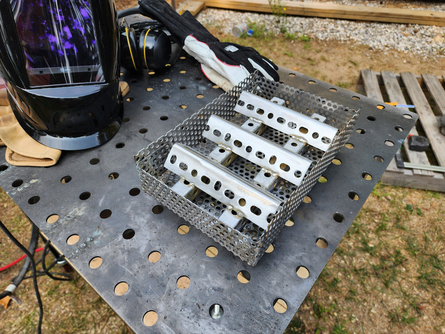 11×7 wood pellet insert with basket artfully set on a welding table with welding mask and gloves.