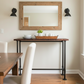 Dining room with wooden table, chairs, and a mirror on the wall.
