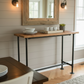 Dining area with wooden table, chairs, and a large mirror on the wall.