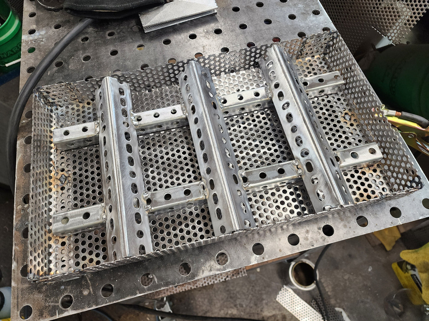 11&quot; x 17&quot; wood pellet insert in a perforated metal basket from a slight angle