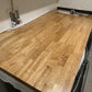 Butcher block countertop, 1.5-inch thick natural wood, over washer and dryer in the laundry room as folding surface.