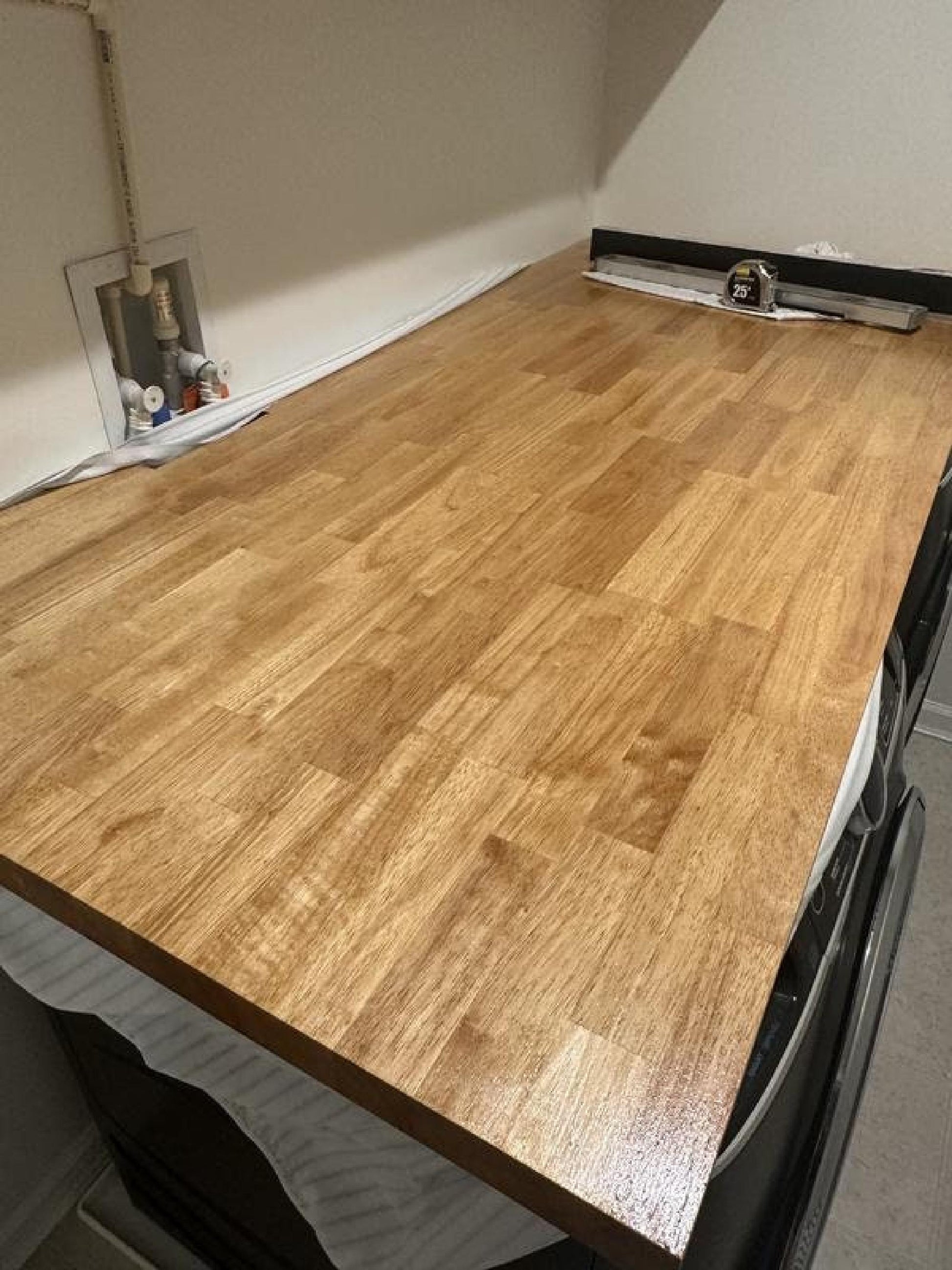 Butcher block countertop, 1.5-inch thick natural wood, over washer and dryer in the laundry room as folding surface.